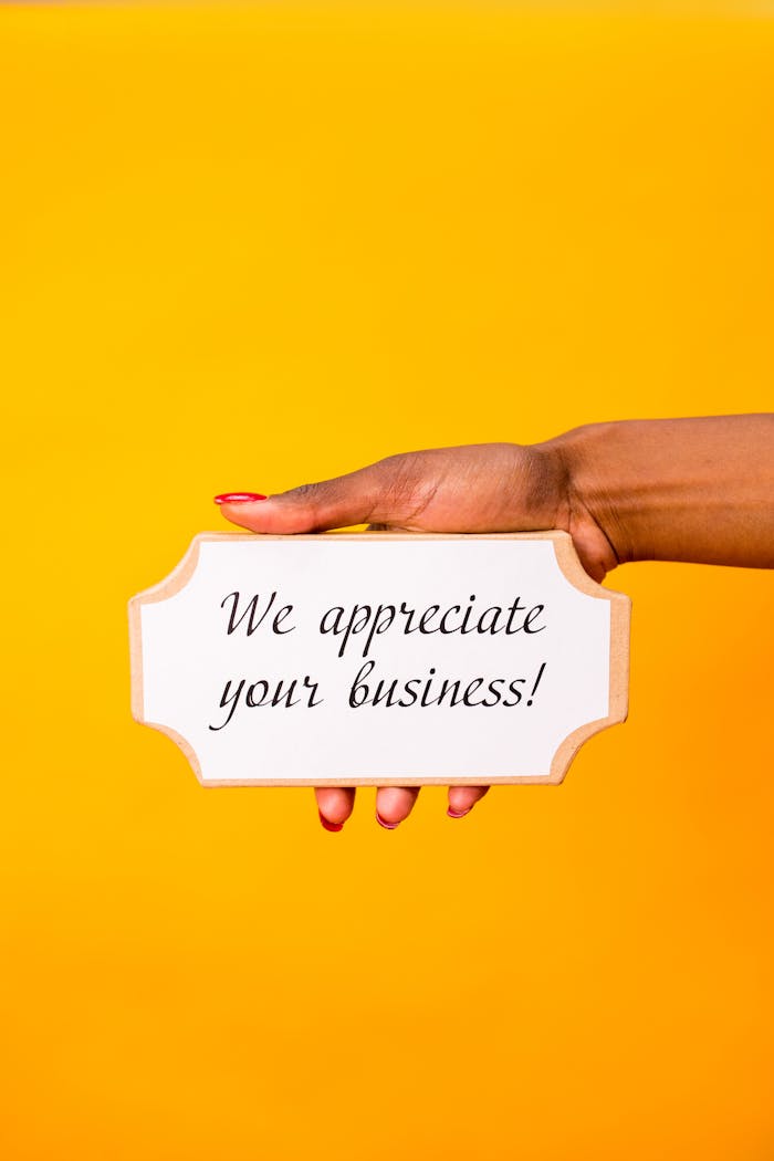 services-04 A hand holding a sign with 'We appreciate your business!' against a yellow background.